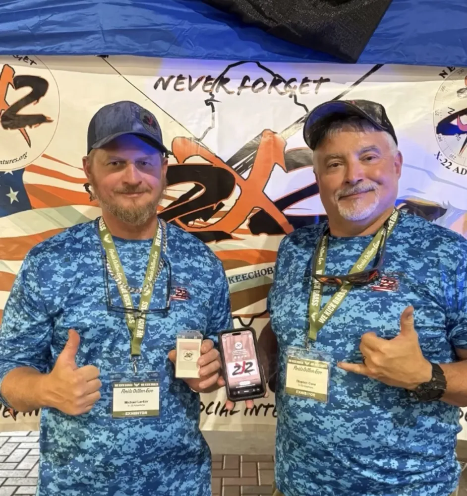 Exhibitors at a trade show booth sharing their page with a Frame Wave tag