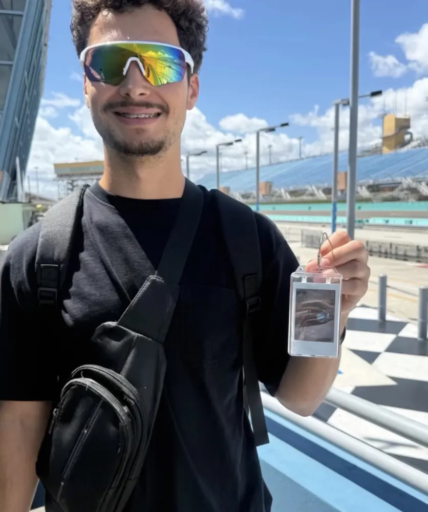 A customer holding a custom Frame Wave tag at a racetrack
