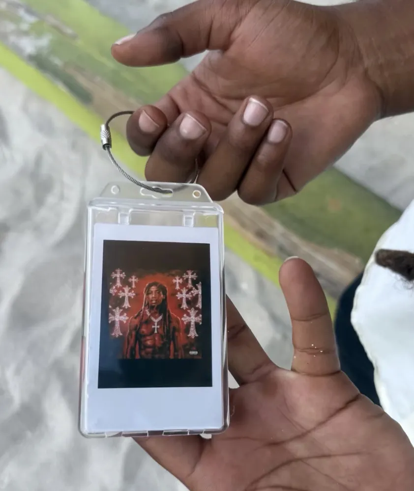 A customer holding a custom Frame Wave tag with their cover artwork
