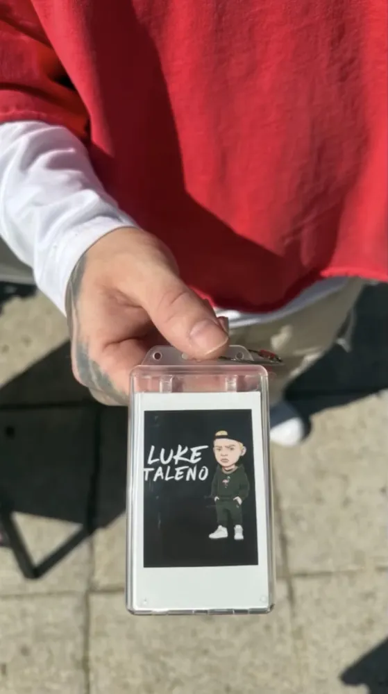 A customer holding a custom Frame Wave tag featuring their artist branding