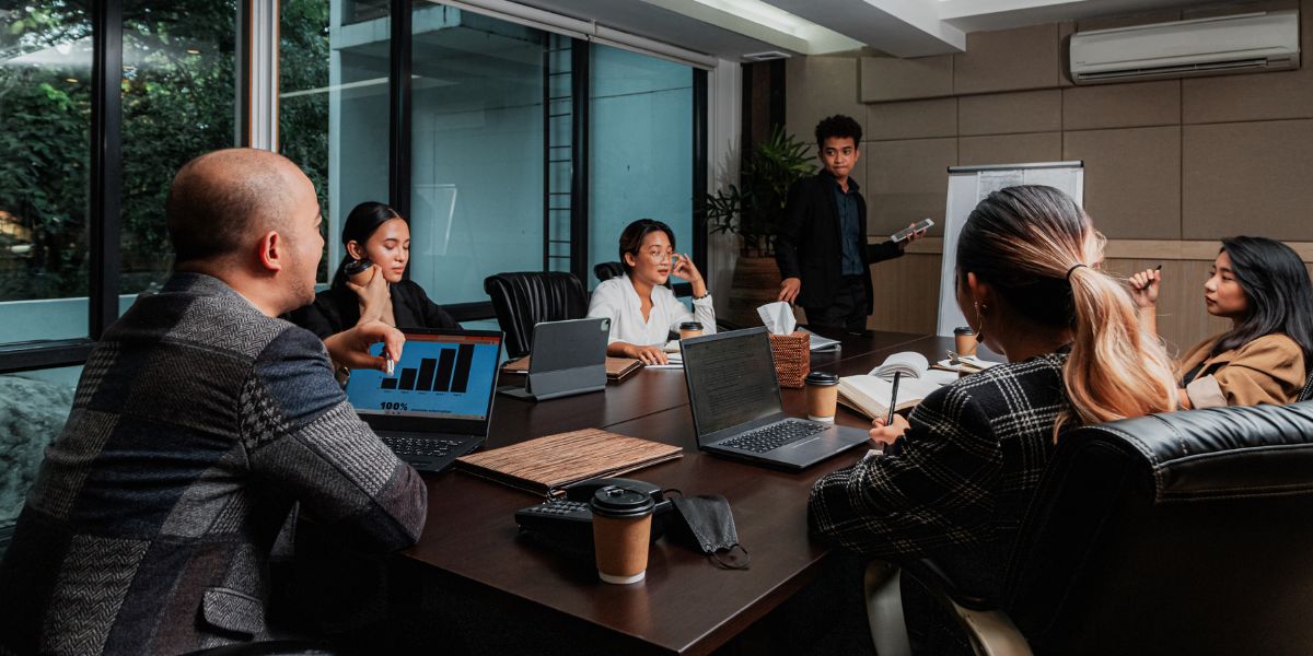 A small team gathered around laptops in a modern office, setting up their digital tools together.